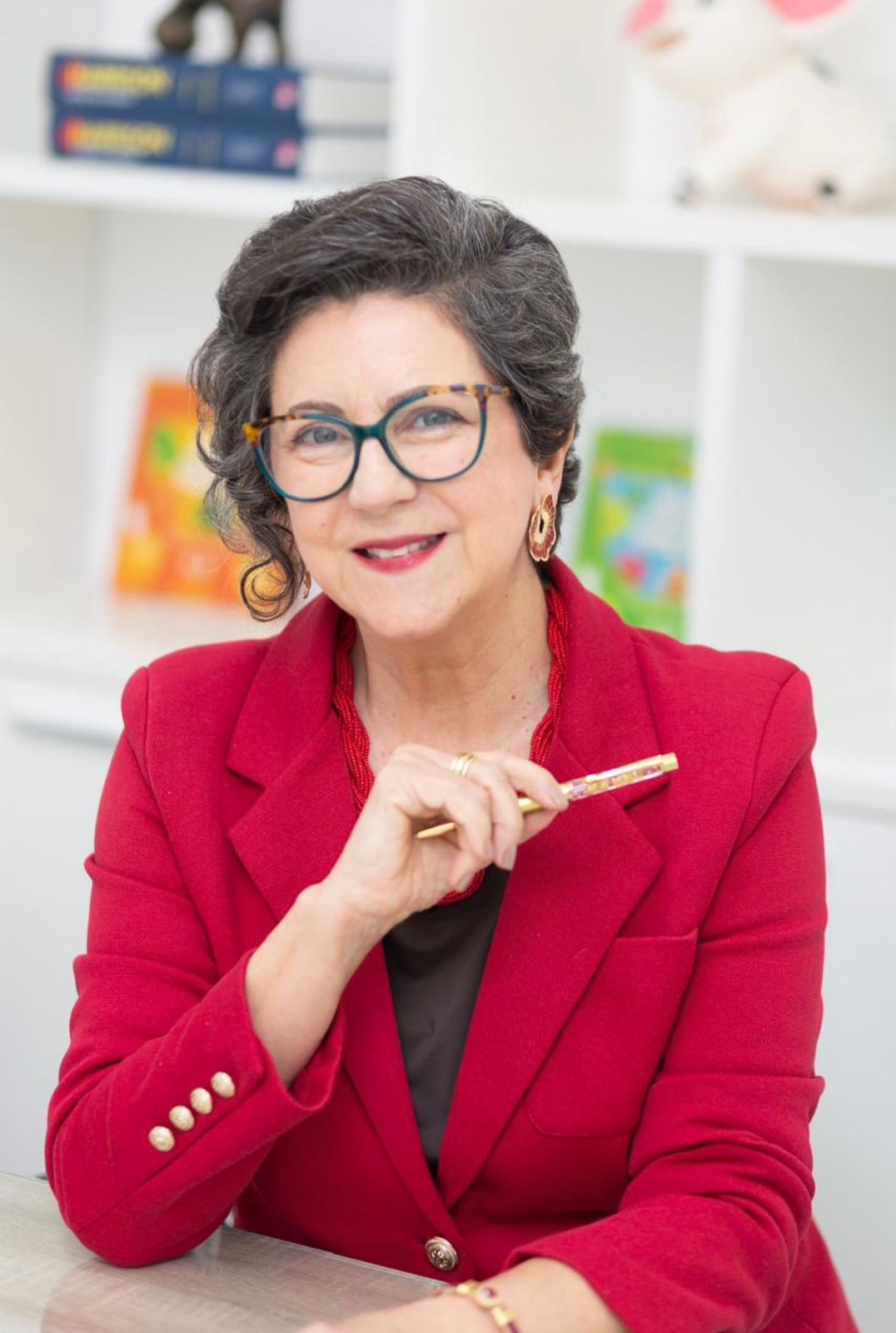 Dra. Sandra em seu consultório pediátrico com livros infantis ao fundo